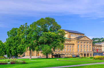 Obraz premium Staatstheater Stuttgart State Theatre, Staatsoper Stuttgart State Opera House and garden with green trees and grass lawn in old town Stuttgart city historic center, Baden-Württemberg state, Germany