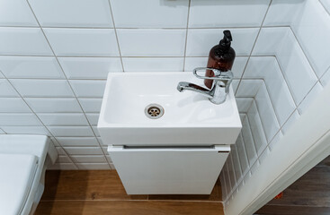 The bathroom features a compact sink along with a toilet, providing essential amenities for personal hygiene in a limited space. Perfect for small living arrangements or guest areas