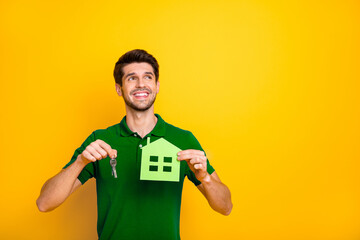 Portrait of his he nice attractive cheerful cheery dreamy guy holding in hands keys and house...
