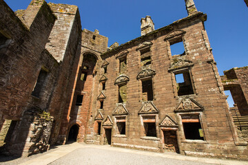 Fototapeta premium The remains of the Nithsdale Lodging within the ruins of Caerlaverock Castle in Scotland on a clear and sunny day.