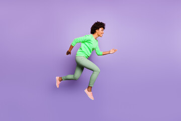Full body profile side photo of positive brunette curly hair dark skin girl hear news fall spring discounts jump run wear yellow pullover green pants trousers isolated violet purple color background