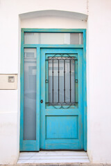 Blue wooden door with black grille in Valencia