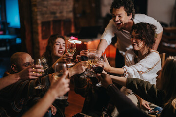 Cheerful friends sharing a toast during a cozy dinner indoors. The atmosphere showcases friendship, celebration, and shared memories in a warmly lit setting, making it a perfect social gathering.