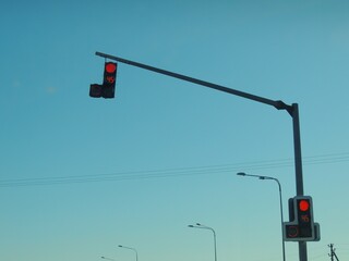 overhead traffic light for cars and pedestrians with red signal color on sky background, number 45 on traffic light board with working prohibitory signal