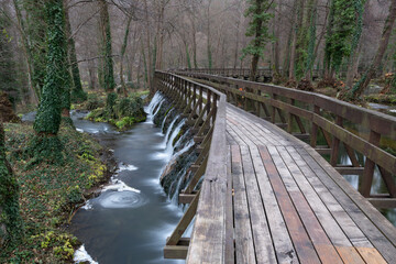 Winding wooden pedestrian bridge on Pliva lake near Jajce