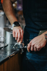 Baristas hands handling a portafilter in a cafe setup, showcasing coffee brewing process