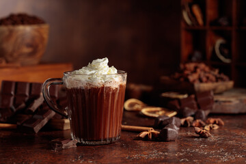 Hot chocolate with whipped cream in a glass mug.