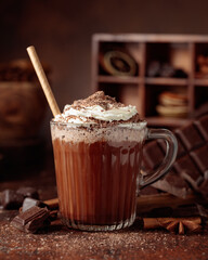 Hot chocolate topped with whipped cream and sprinkled with chocolate chips.