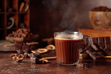 Hot chocolate with ingredients on a brown background.