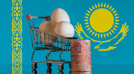 Chicken eggs in a miniature shopping cart against the background of the Kazakhstan flag