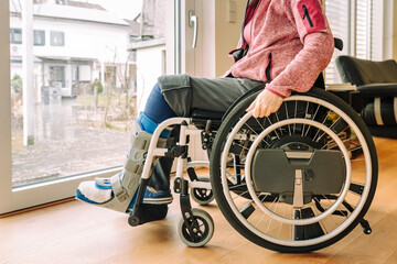 Detail or woman in a wheelchair with leg brace after sport injury
