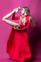 Obraz premium Sexy slim woman posing with High heels. Female sexy shoes. High heels, fashion shoe. Fashionable shoe store. Fashion model hold High heels. Trendy fashion high heeled shoes.