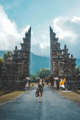 Young Woman Running Through Handara Gate In Bali, Indonesia