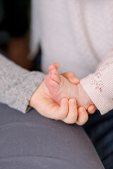 A child holding her baby sister's foot