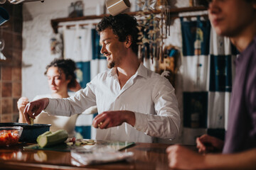 A group of smiling friends gather in a warmly lit kitchen preparing a meal together. The scene captures camaraderie, enjoyment, and connection around the joy of cooking and sharing food.