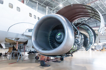 Close-up of an open high bypass turbofan aircraft engine of a passenger airliner in airplane hangar