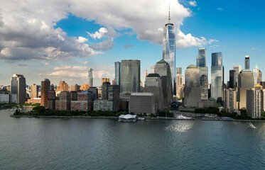Obraz premium NYC aerial skyline, New York. Panorama view of New York city skyscrapers on blue sky. USA NYC. Lower NYC skyline on sunny day. New York cityscape. New York City with clouds from drone.