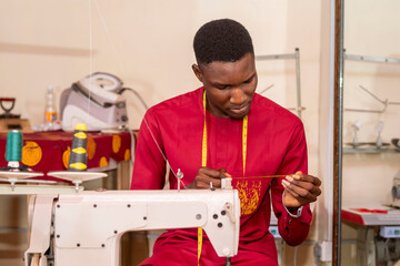 male african tailor sewing with her machine