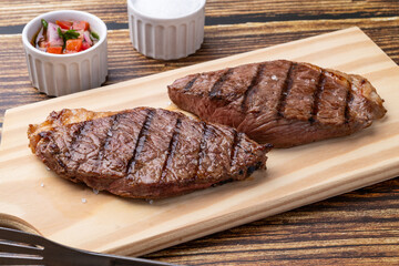 Grilled picanha beef over wooden board with vinaigrette