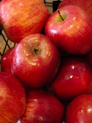 Freshly picked red apples piled together in a rustic basket ready for a farm market visit this autumn season
