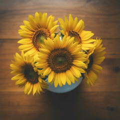 Bright yellow sunflowers in glass vase top view rustic wooden table floral still life warm natural tones