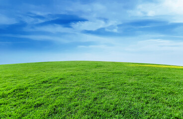 Green grassland landscape, blue sky and clouds panoramic background, outdoor atmosphere, refreshing and relaxing feeling.