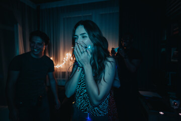 Friends celebrating a joyous evening at home with laughter and excitement