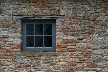 An old timber window in old brick wall