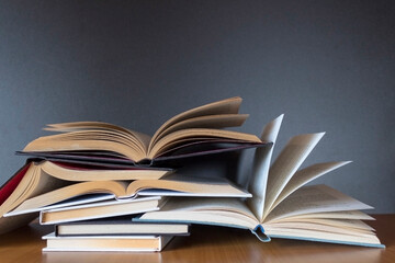 Pile of books on wooden table with dark background and copy space.