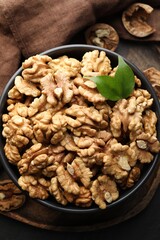 Fresh ripe walnuts in bowl on table, top view