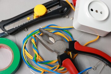 Different electrical tools on grey table, above view