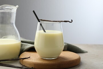 Delicious vanilla milk and pods on grey table