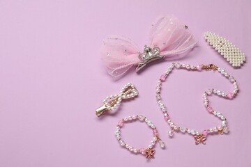 Cute hair accessories on lilac background, flat lay. Space for text