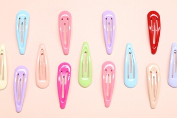 Colorful hair clips on light background, flat lay