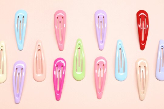Colorful hair clips on light background, flat lay