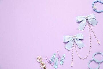 Cute hair accessories on lilac background, flat lay. Space for text