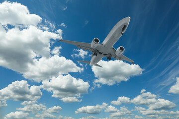 Airplane flying in beautiful blue sky with clouds