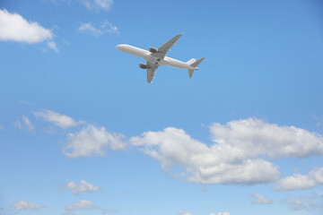 Airplane flying in beautiful blue sky with clouds