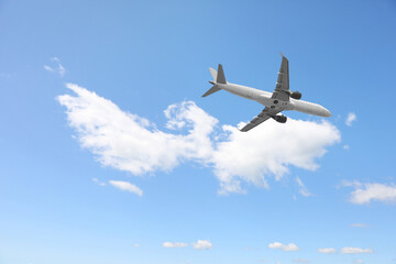 Airplane flying in beautiful blue sky with clouds
