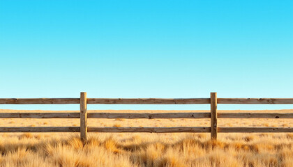 Obraz premium Rustic wooden fence against a clear blue sky on a vast cattle ranch, minimal yet powerful representation of the livestock industry.