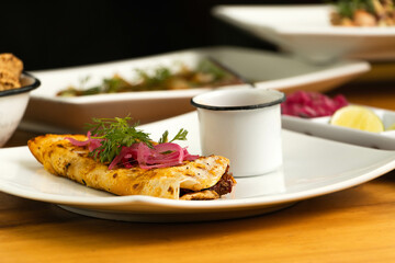 Taco&acute;s birria with other food in the background