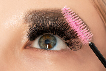 Beautiful Woman with long eyelashes in a beauty salon. Eyelash extension procedure. Lashes close up