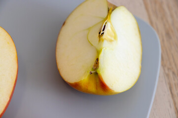 Freshly sliced apple showcasing its juicy, crisp texture and vibrant colors on a minimalist gray plate, ideal for healthy eating concepts and food photography.