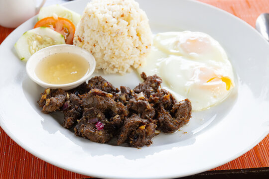 Tapsilog Philippines breakfast with Two eggs and rice.