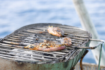 Cooking fish on BBQ while on Boat tour in Coron Philippines 