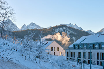 Buildings covered in snow with clear sky and morning golden hour light, alpine architecture...