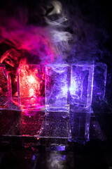 Crystal clear frosty textured natural ice block with cracks on black mirroring surface.