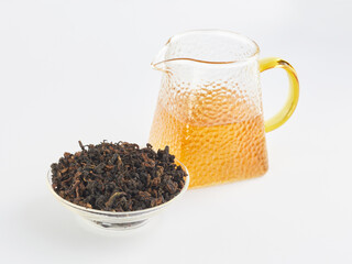 dried Chinese tea leaves and brewed drink in a transparent teapot on a white background