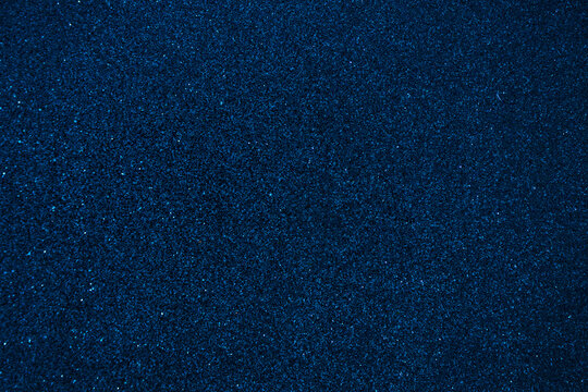 Shiny navy blue glitter texture background. Festive sparkly shiny wrapping paper background