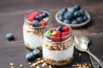 Yogurt Parfait  With Granola And Berries In Jar On Wooden Table